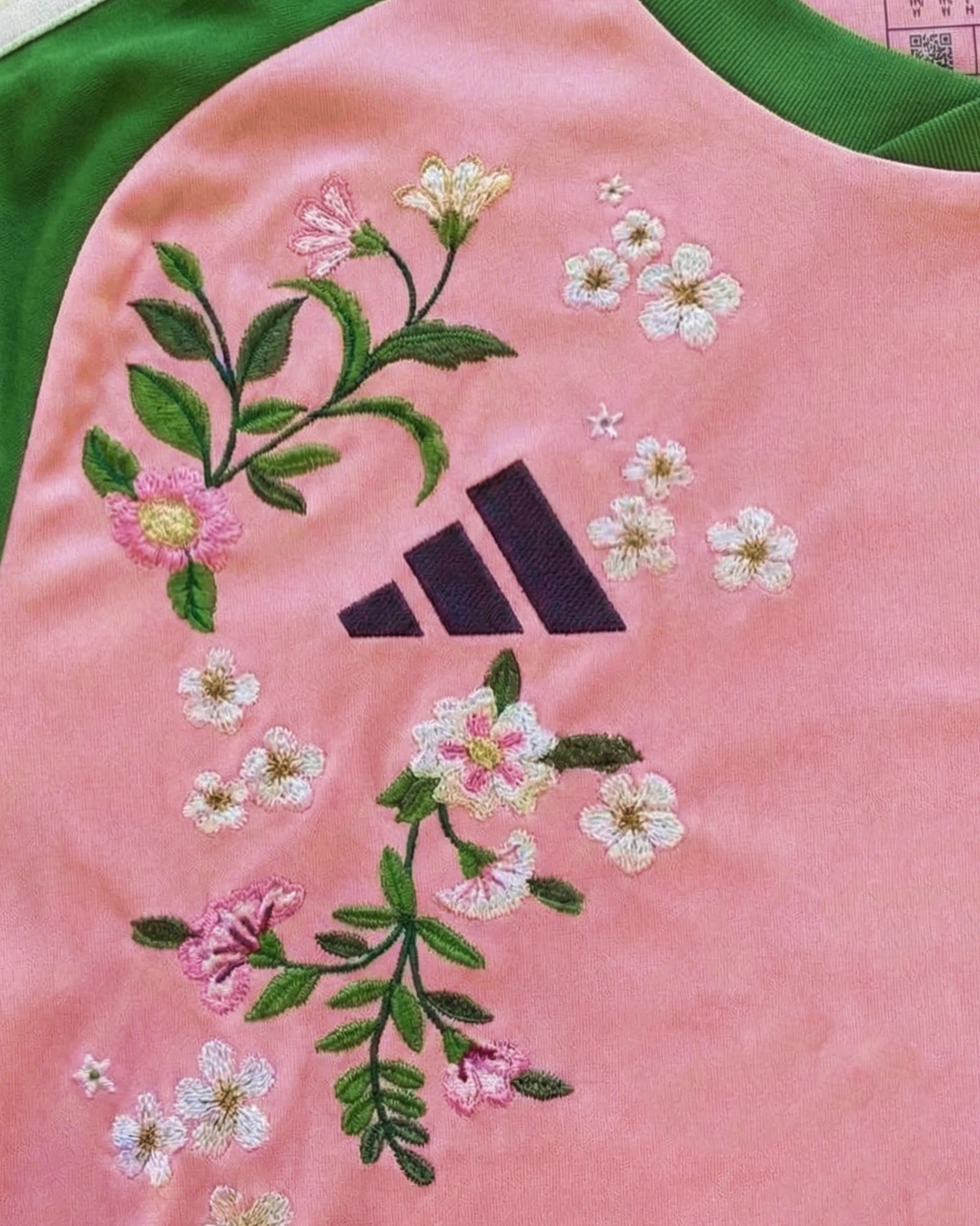 Close-up hand-embroidered cherry blossom and sakura detail on Japan concept jersey — botanical embroidery Paris & Versailles — VOLTA