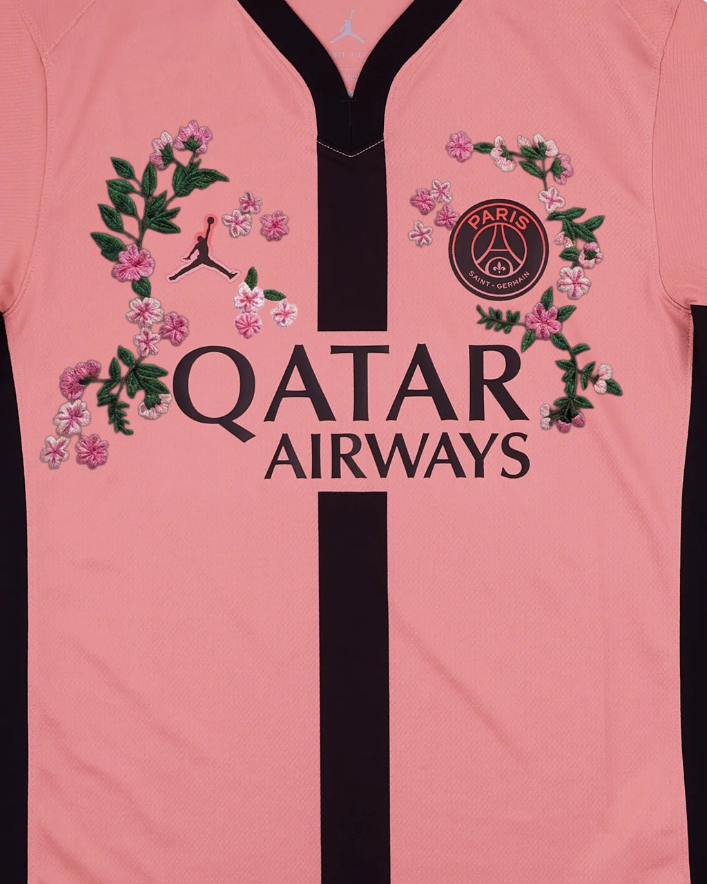 PSG badge and Jumpman detail surrounded by hand-embroidered cherry blossom wreaths on pink concept jersey — botanical embroidery Paris & Versailles — VOLTA Avenue Rose Edition