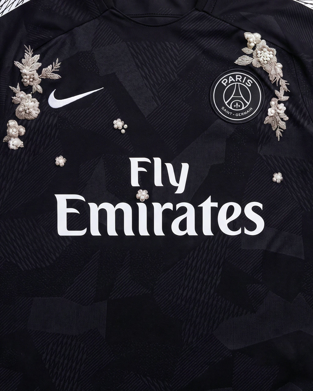 Medium Shot Detail Of the Paris Concept Jersey Chest, Illustrating Symmetrical Silver Botanical Embroidery Encrusted With 3D Pearls Flanking The White Sponsor Text.
