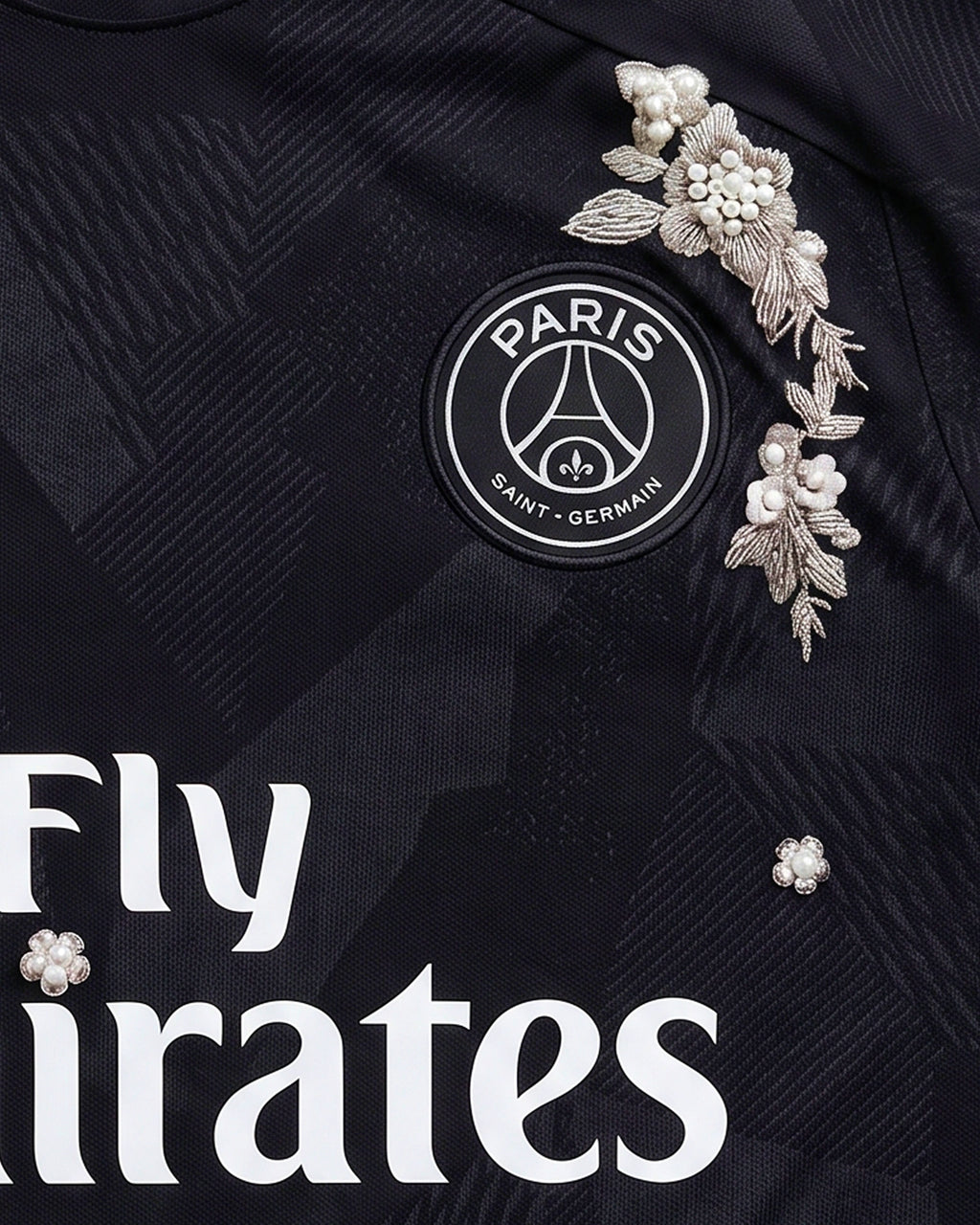 Macro Texture Shot Of The Right Chest On The Paris Retro Shirt Revisited, Showcasing Elegant Hand-Guided Silver Leaf Stitching and Scattered Ivory Pearls Floating Around The White Brand Swoosh.