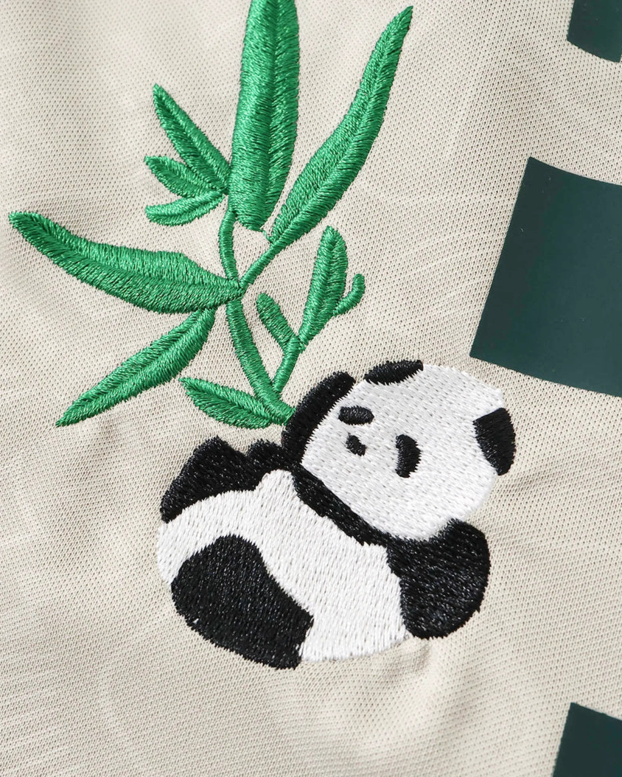 Ultra close-up hand-embroidered giant panda in black and white thread with green bamboo leaves — Bayern Munich Hellabrunn Edition — VOLTA Paris & Versailles