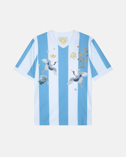 Argentina hand-embroidered concept jersey front view — soaring cranes, gold botanical branches and white star flowers on authentic albiceleste stripes — VOLTA Albiceleste Rising Edition