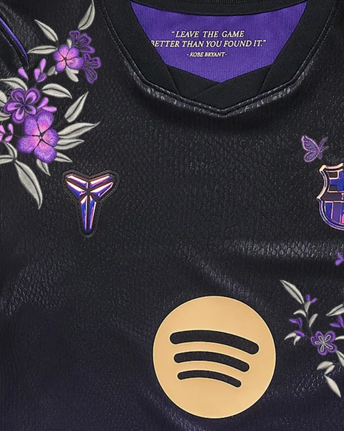 Close-up of hand-embroidered violet blossoms and silver leaves on the left shoulder of the Barcelona jersey