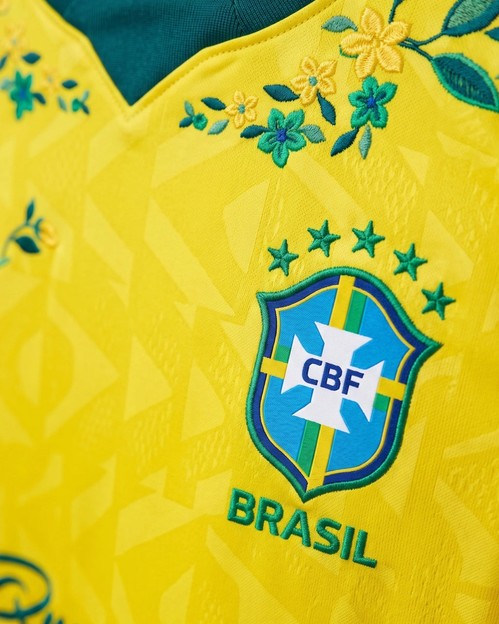 CBF Brasil badge with five stars and hand-embroidered botanical collar wreath in yellow, teal and dark green on authentic Brazil 2026 World Cup concept jersey — VOLTA Canarinha in Bloom Edition