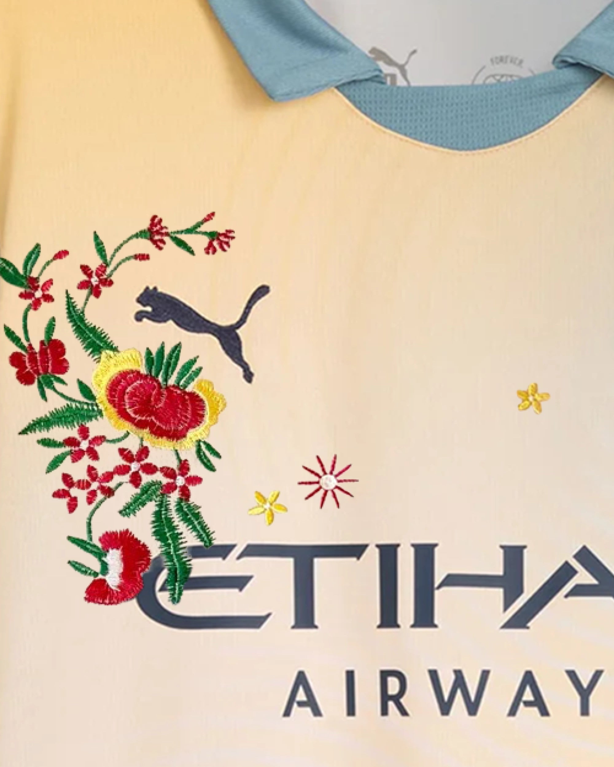 Macro Texture Shot On The Left Chest Of The Custom Embroidered Noel Gallagher Shirt, Showcasing Premium Yellow Rose Embroidery Encasing The Iridescent Manchester City Crest.