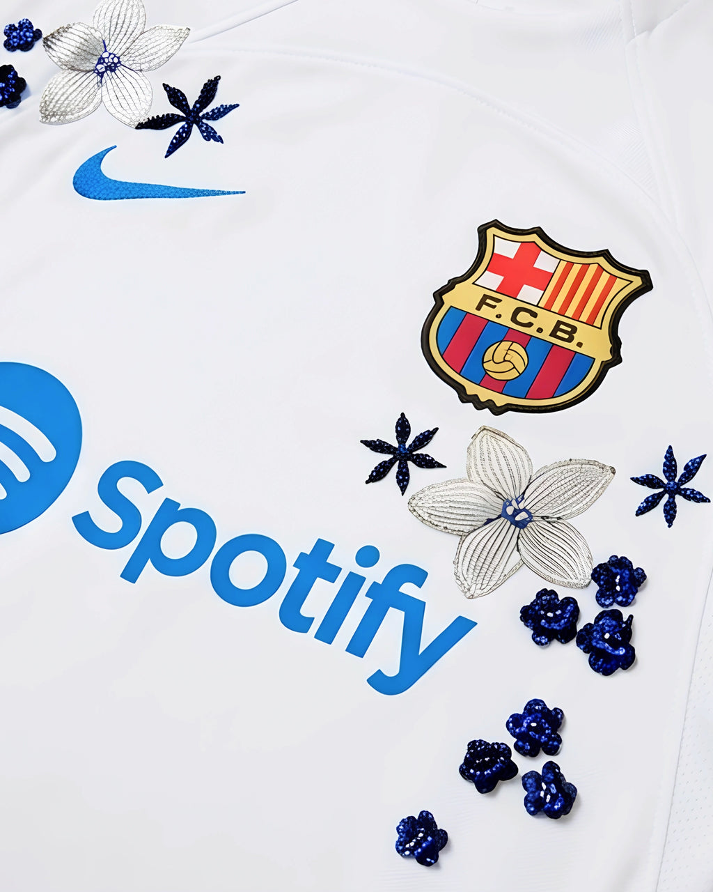 Macro Texture Shot Focusing On The Left Torso Detail Of The Custom Embroidered White Barcelona Shirt, Highlighting The Dense Haptic 3D Thread Quality Of Silver Flowers.