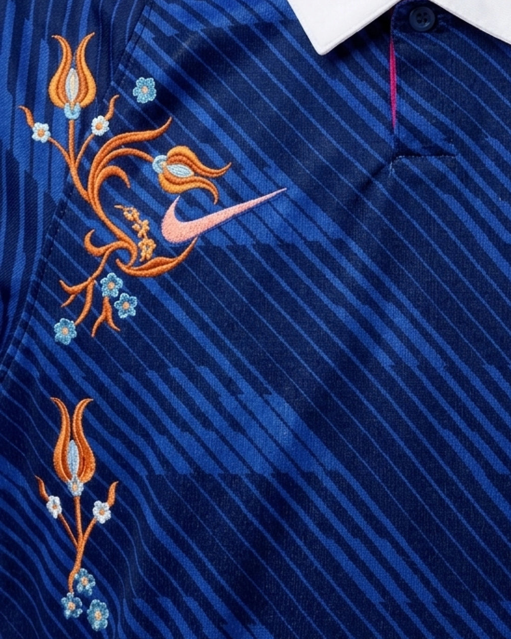 Close-Up Macro Focus On The Right Chest Of The Custom France Home Kit, Highlighting The Brand Logo Entwined In High-Density Hand-Guided Orange Flower Embroidery.