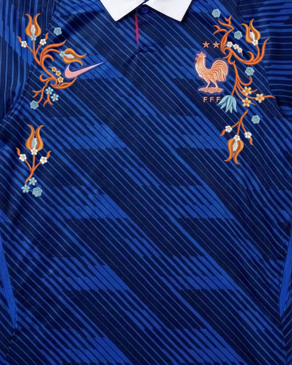 Upper Torso Detail Shot Of The France World Cup Jersey Reimagined, Displaying The Symmetrical Layout Of Coppery Orange And Light Blue Floral Embroidery On The Chest.