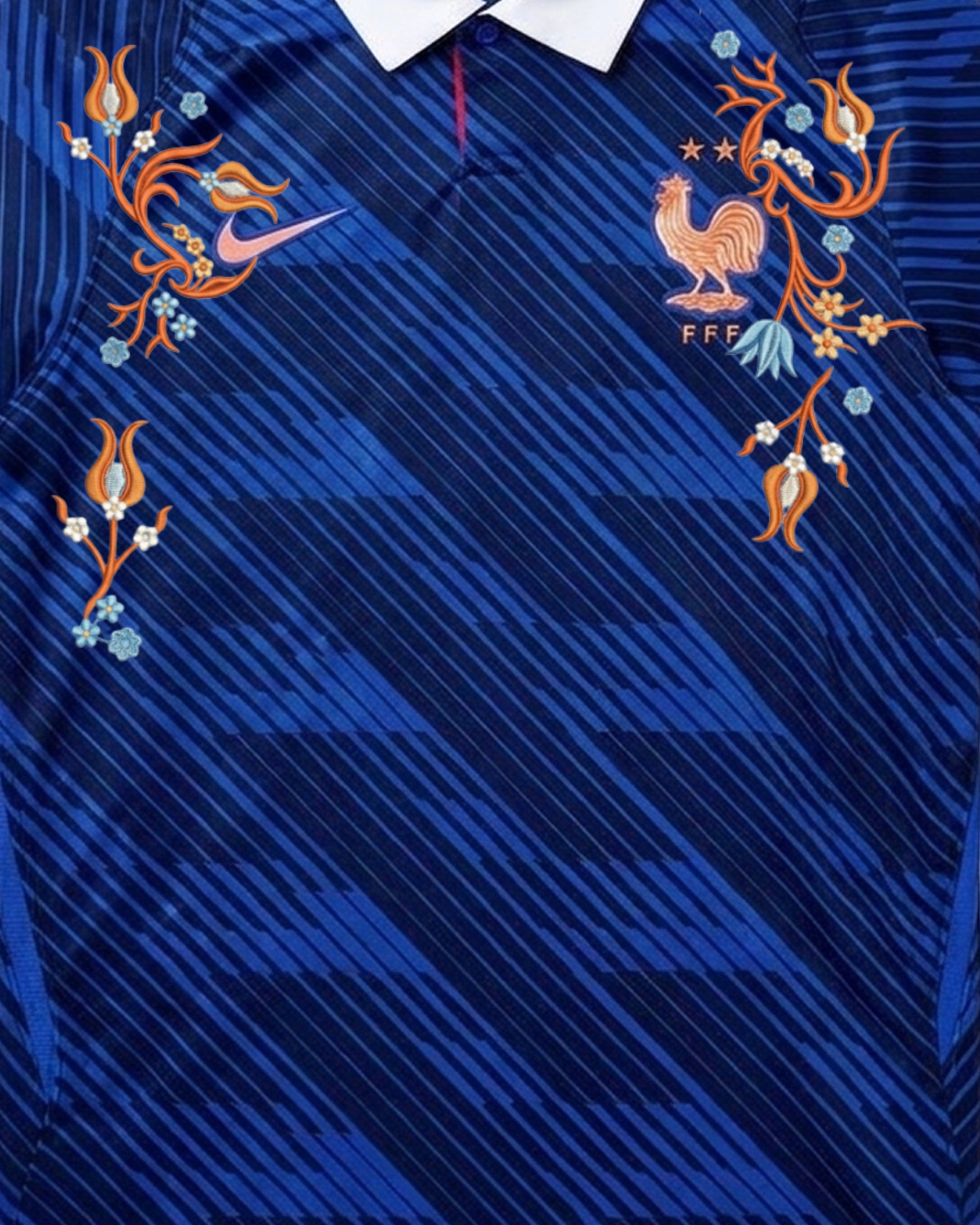 Upper Torso Detail Shot Of The France World Cup Jersey Reimagined, Displaying The Symmetrical Layout Of Coppery Orange And Light Blue Floral Embroidery On The Chest.