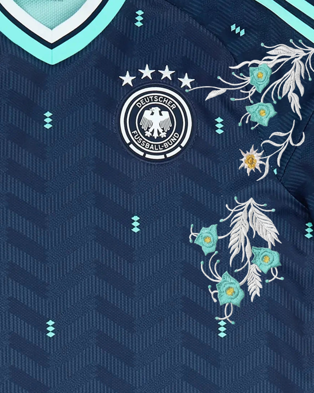 Close-Up Shot Of The Germany World Cup Jersey Reimagined Left Chest, Highlighting The Four-Star German Eagle Crest Wrapped In High-Density Silver Mountain Vine Embroidery.