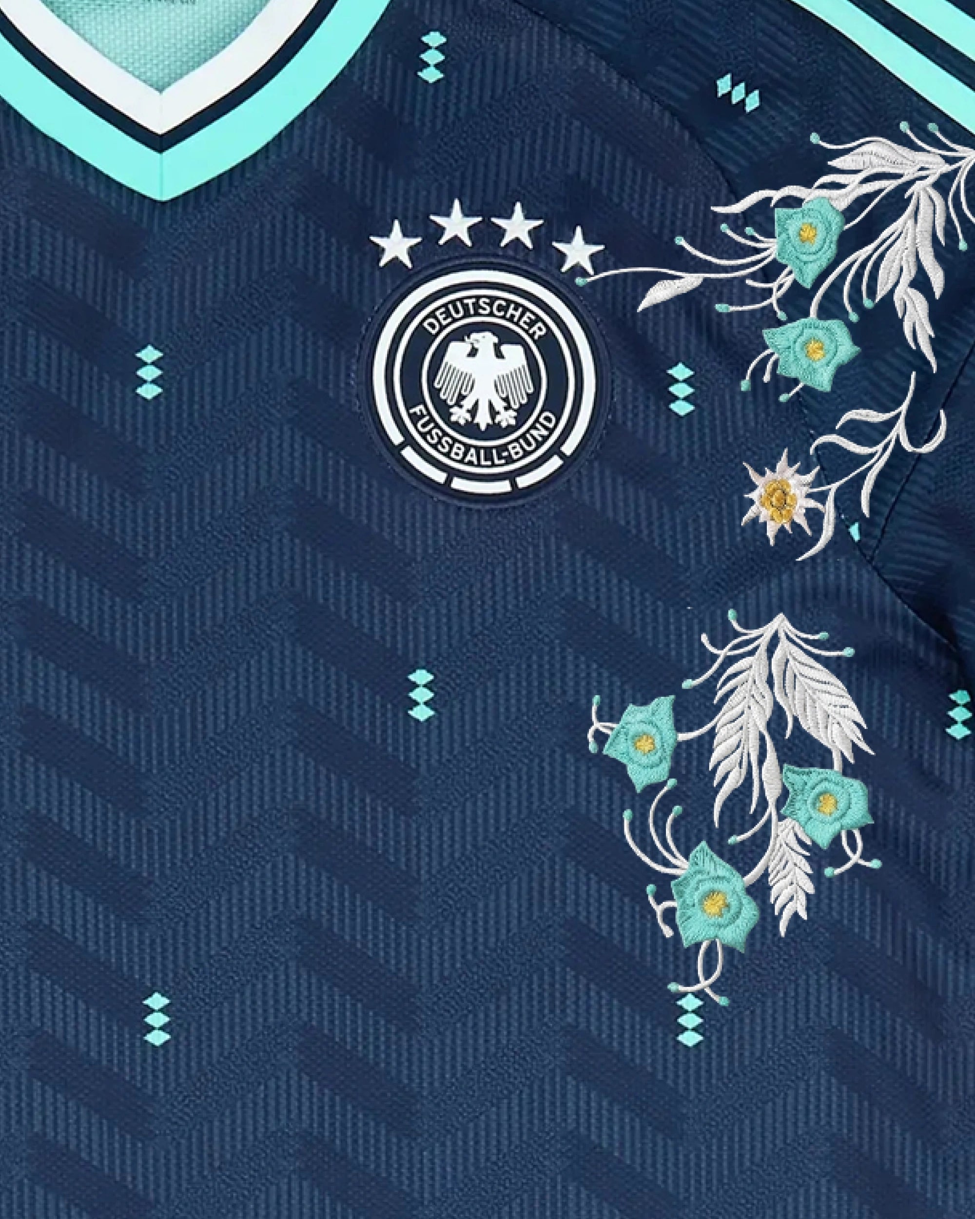 Close-Up Shot Of The Germany World Cup Jersey Reimagined Left Chest, Highlighting The Four-Star German Eagle Crest Wrapped In High-Density Silver Mountain Vine Embroidery.