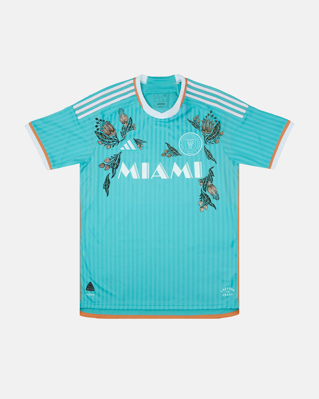 Full front view of the Inter Miami Blue Jersey Reimagined (Ocean Drive Edition), showcasing the ocean blue base decorated with hand-embroidered pink hibiscus flowers.