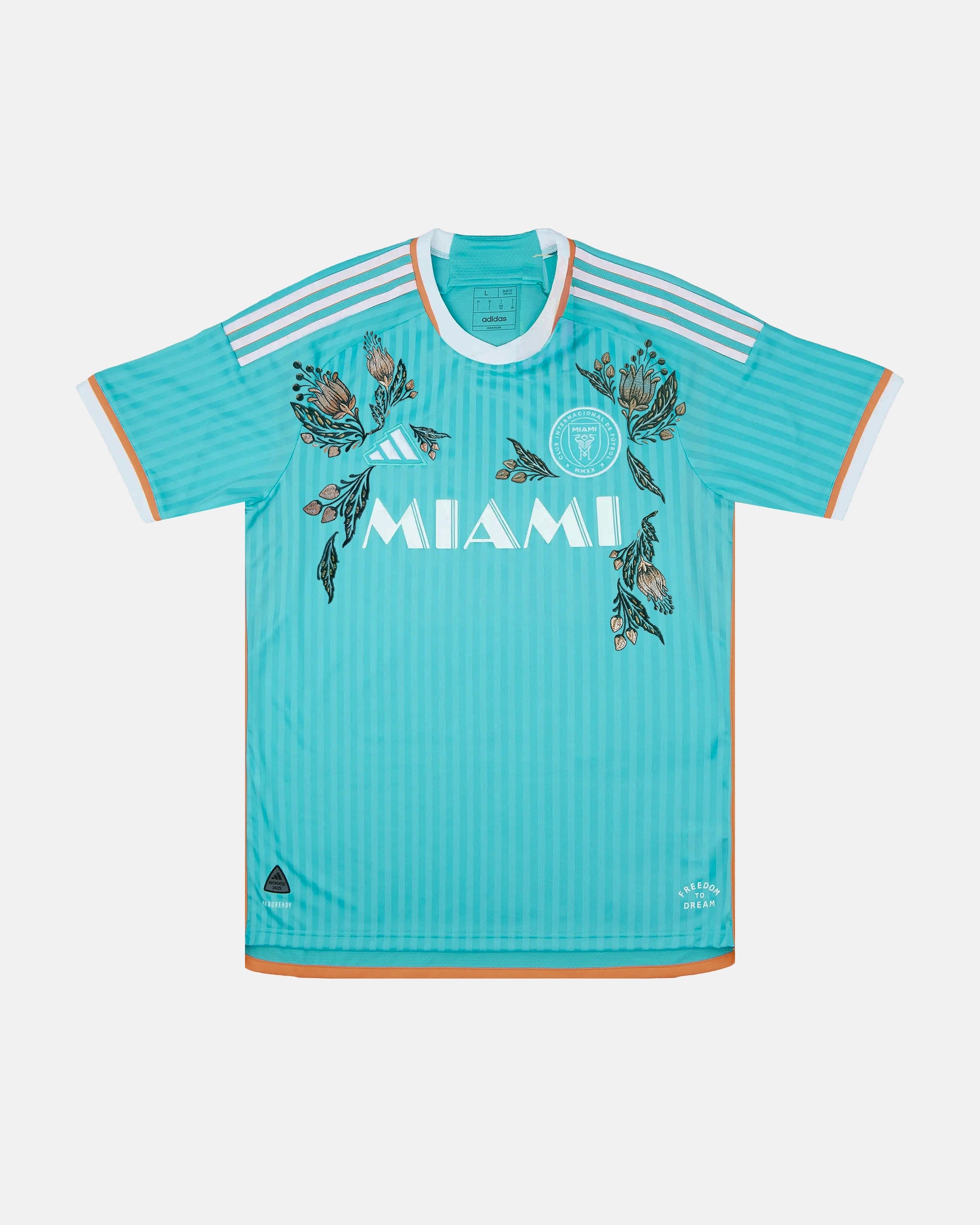 Full front view of the Inter Miami Blue Jersey Reimagined (Ocean Drive Edition), showcasing the ocean blue base decorated with hand-embroidered pink hibiscus flowers.