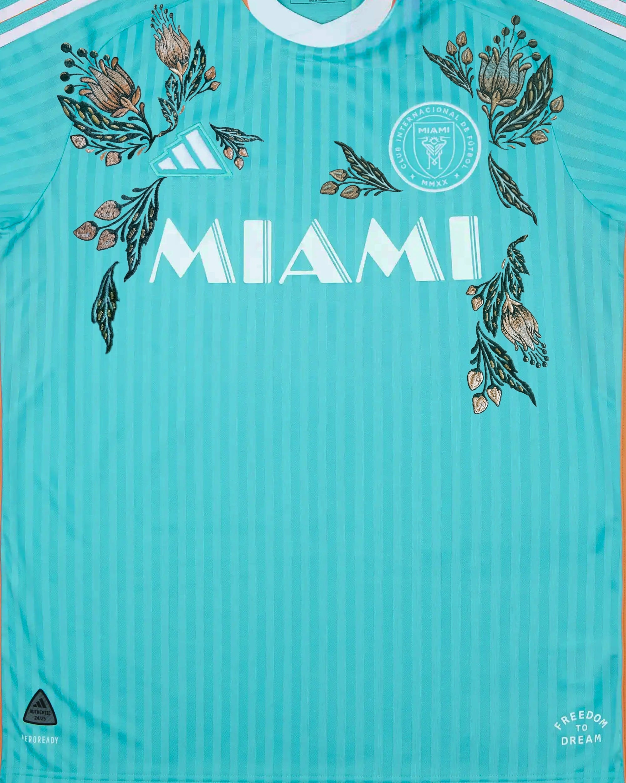Close-up macro detail of the Inter Miami Concept Jersey crest, featuring pristine stitching around the retro emblem and rich botanical embroidery.