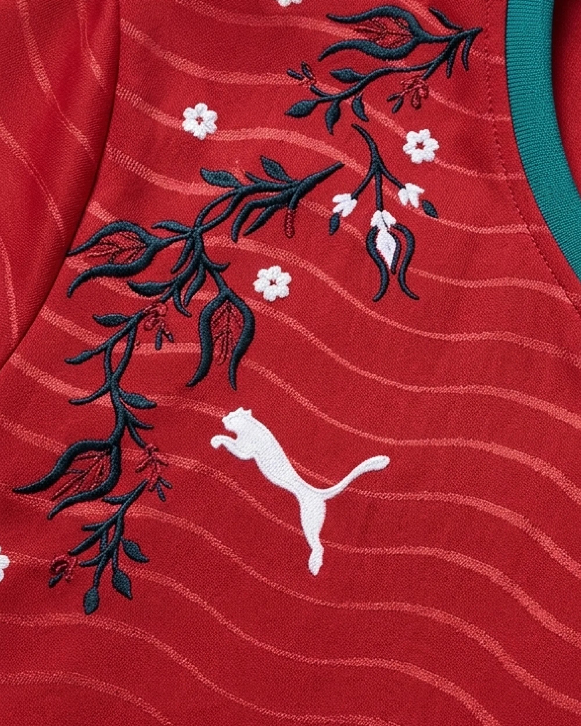 Macro Texture Shot Focusing On The Right Chest, Showcasing The White Leaping Brand Logo Integrated With Intricate Hand-Guided Botanical Vines And Petals.