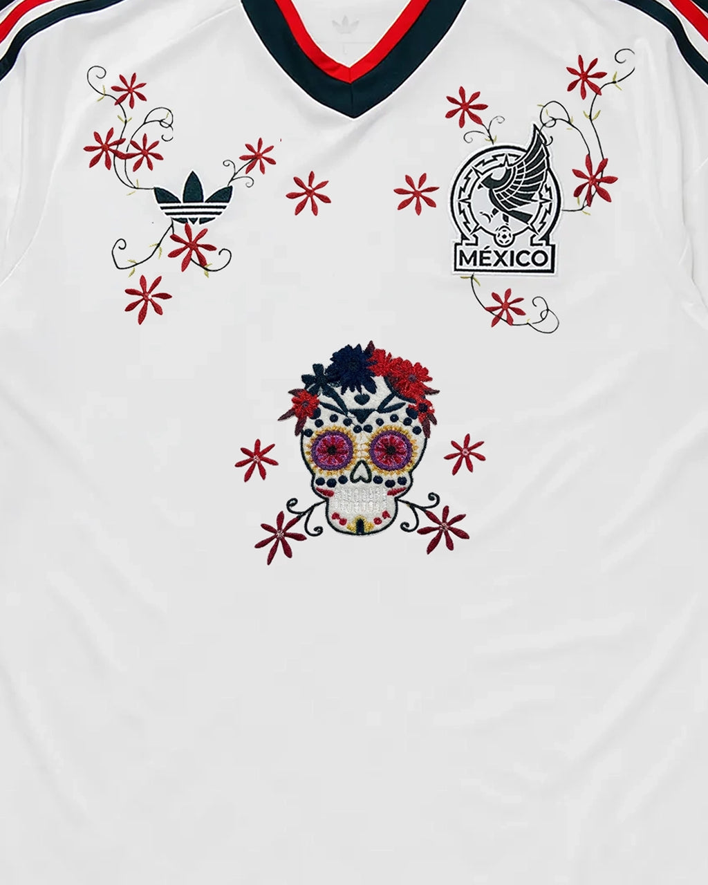 Centered Upper Torso Shot Of The Mexico Embroidered Jersey 2026, Displaying The Complete Composition Of The Sugar Skull And Crimson Vines Framing The Crest.