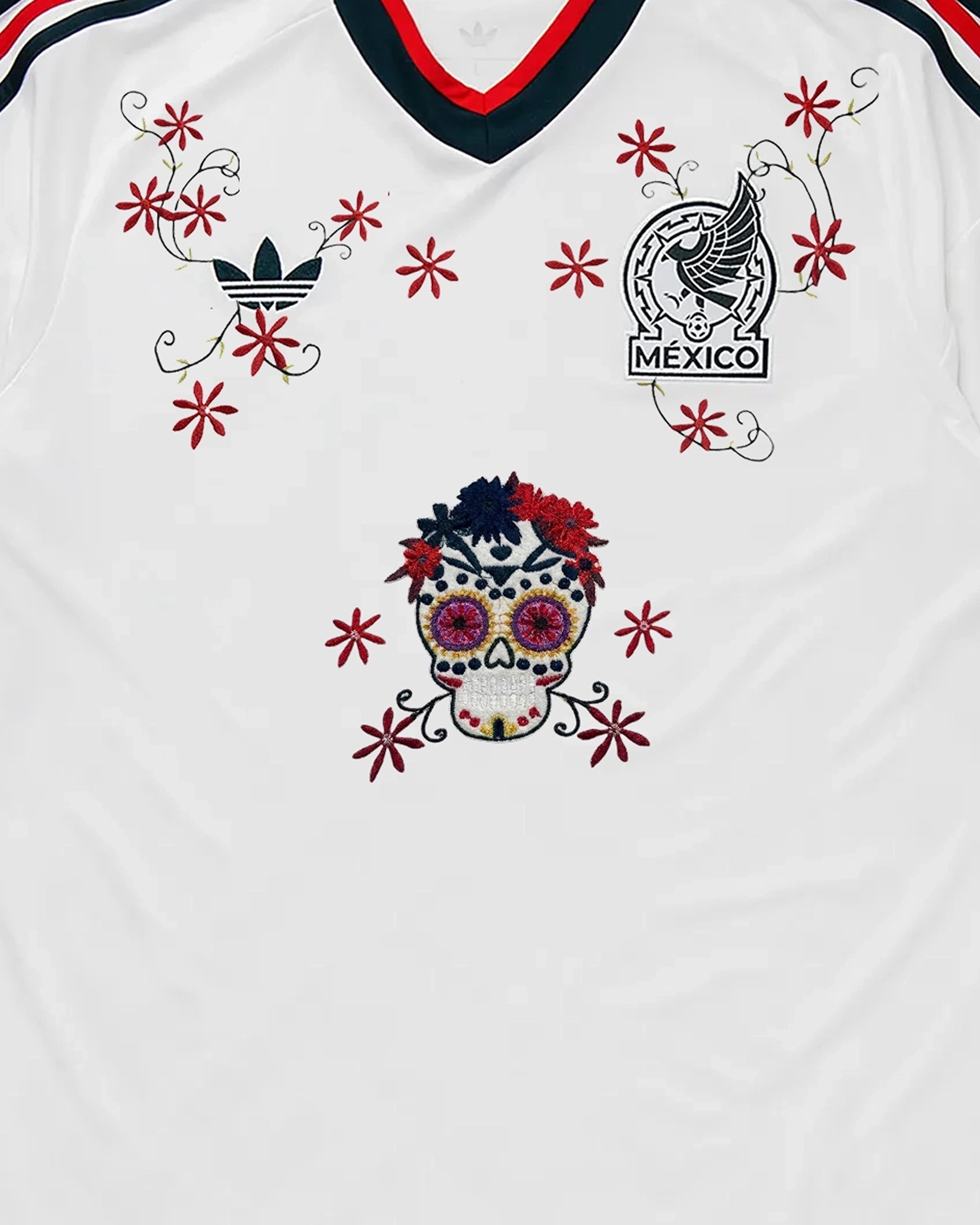 Centered Upper Torso Shot Of The Mexico Embroidered Jersey 2026, Displaying The Complete Composition Of The Sugar Skull And Crimson Vines Framing The Crest.