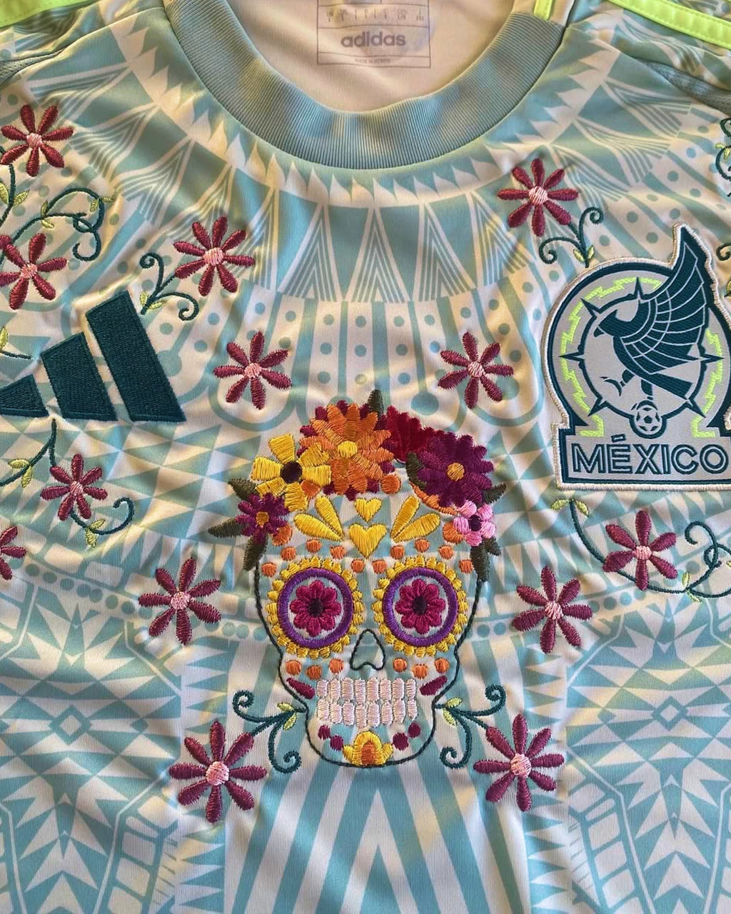 Close-Up Macro Shot Of The Mexico Jersey 2024/25 Reimagined Torso, Highlighting The Dense Haptic 3D Thread Quality Of The Central Embroidered Sugar Skull Graphic.