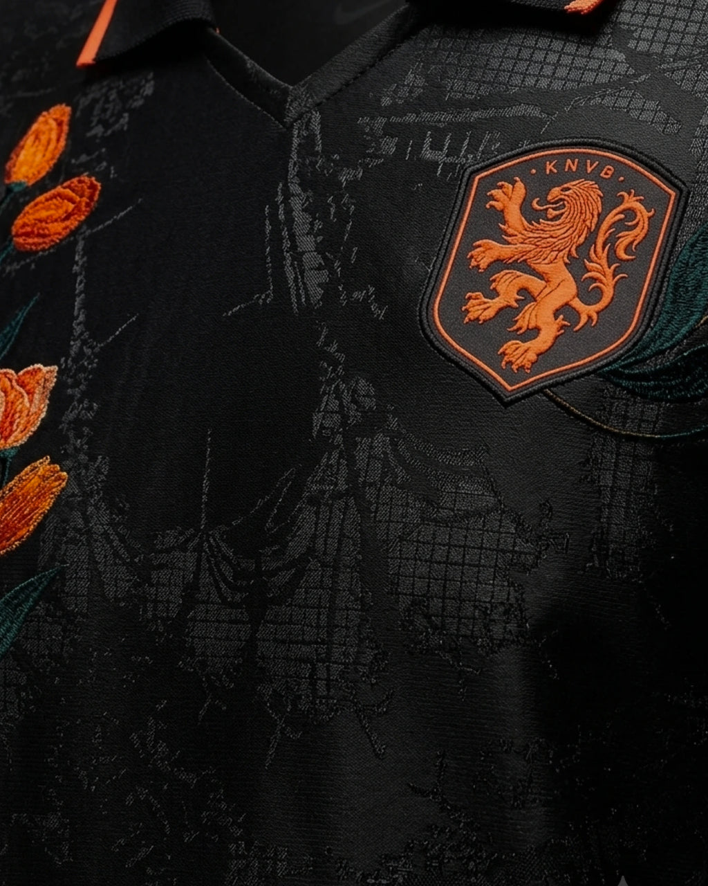 KNVB Netherlands lion badge close-up with hand-embroidered orange and teal tulip stems on black jacquard concept jersey — VOLTA Black Tulip Edition Paris & Versailles