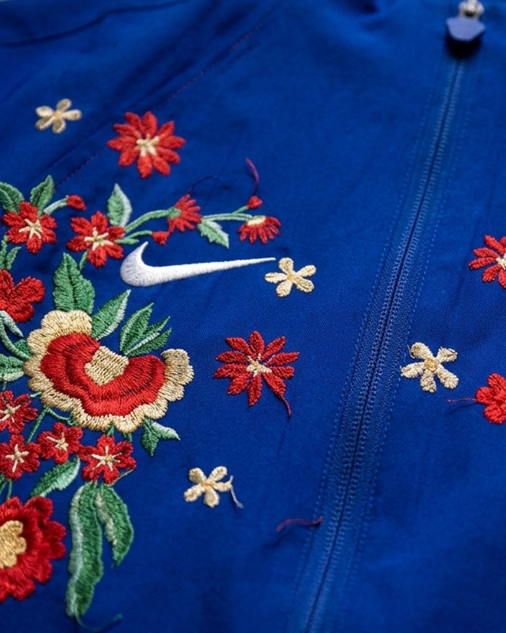 Embroidered floral cascade climbing toward the red sleeve on the PSG ‘Fleur de Paris’ jacket