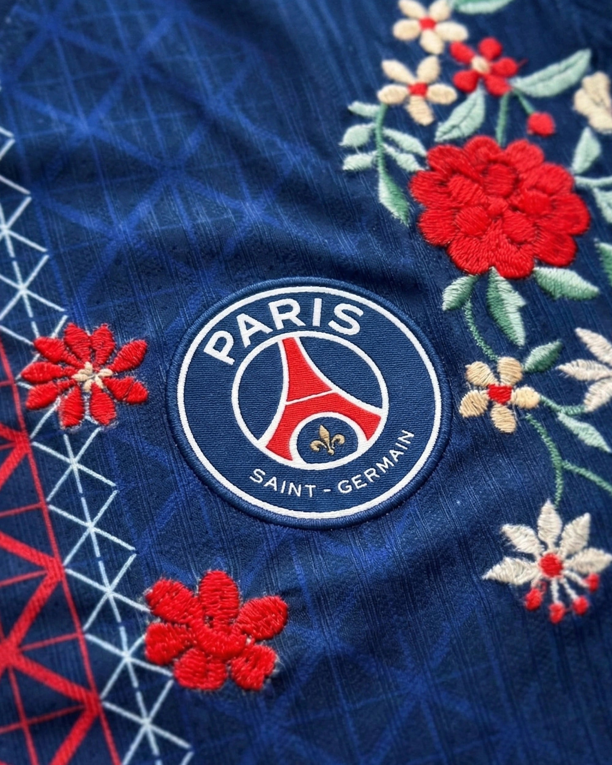 PSG badge detail on hand-embroidered concept jersey — Paris Saint-Germain floral embroidery — VOLTA