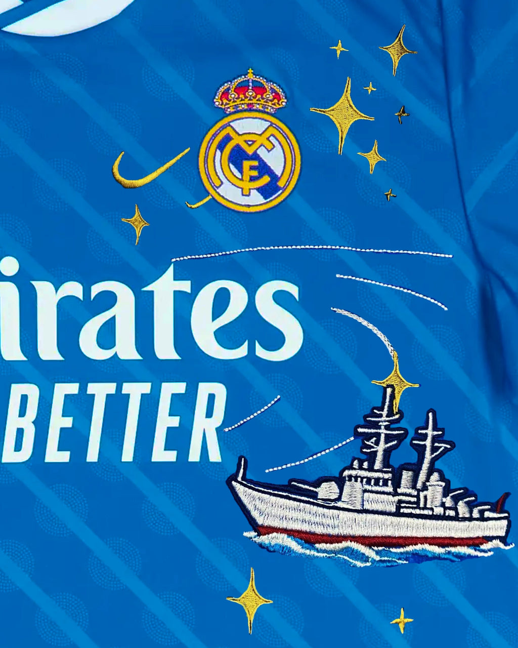 Close-Up Macro Detail On The Left Chest Of The Real Madrid Away Kit Revisited, Highlighting The Dense Haptic 3D Thread Quality Of A Naval Destroyer Firing A Missile Next To The Crest.