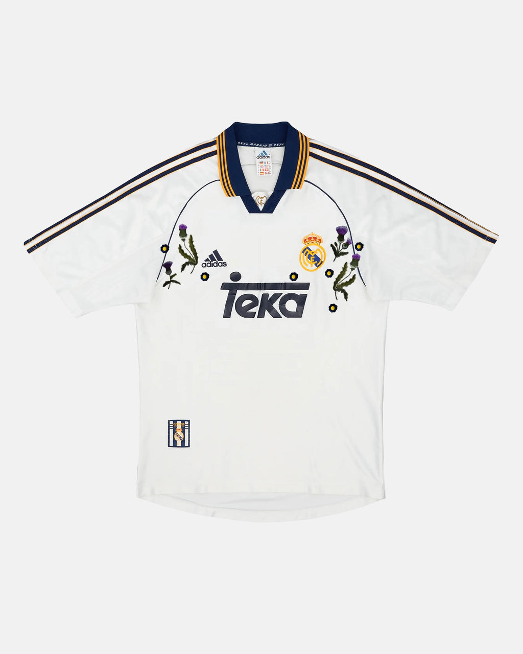 Full Front View Of The Bespoke Real Madrid Embroidered Jersey (Castilian Thistle Edition), Showcasing The White 1999/2000 Base Woven With Hand-Stitched Purple Thistles.