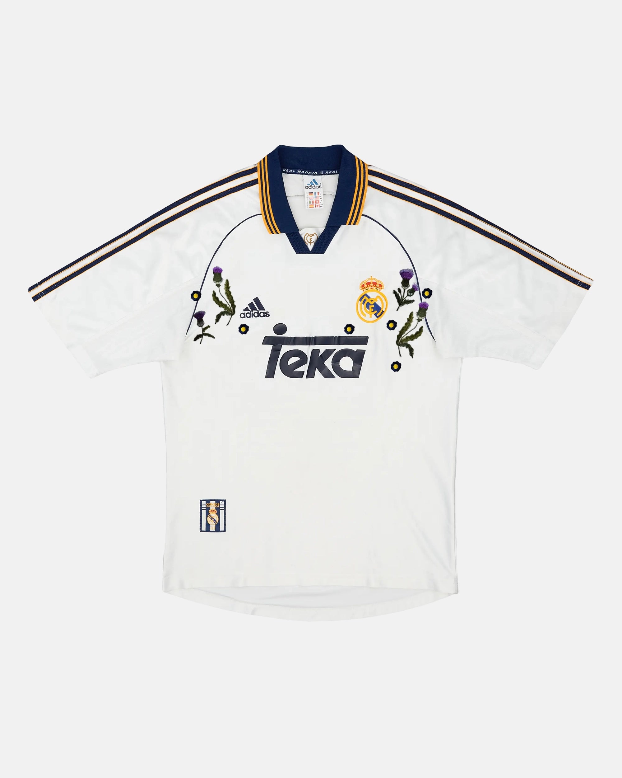 Full Front View Of The Bespoke Real Madrid Embroidered Jersey (Castilian Thistle Edition), Showcasing The White 1999/2000 Base Woven With Hand-Stitched Purple Thistles.